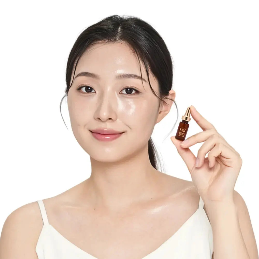 Model holding KDL Brightening Booster Ampoule that helps reduce dark spots and enhance skin radiance.