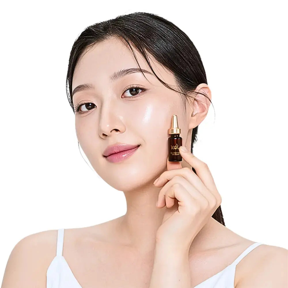 Model holding KDL Revital Lift Booster Ampoule that firms and smooths aging skin.
