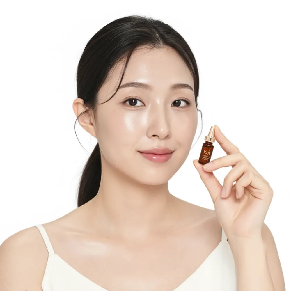 Model applying KDL Brightening Booster Ampoule for a radiant and luminous complexion.