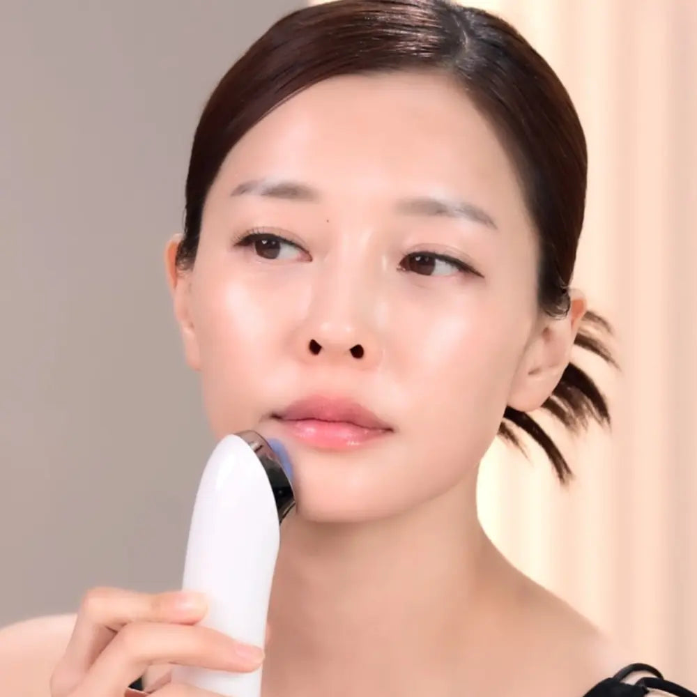 Woman using the VERYAN PRO EMS facial device along the chin and jawline during her home skincare routine