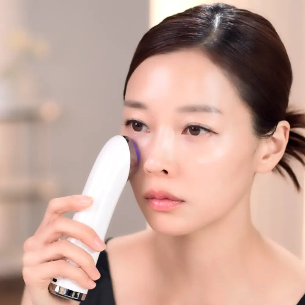 Woman using the VERYAN PRO Korean facial device on her cheek as part of an at-home skincare routine